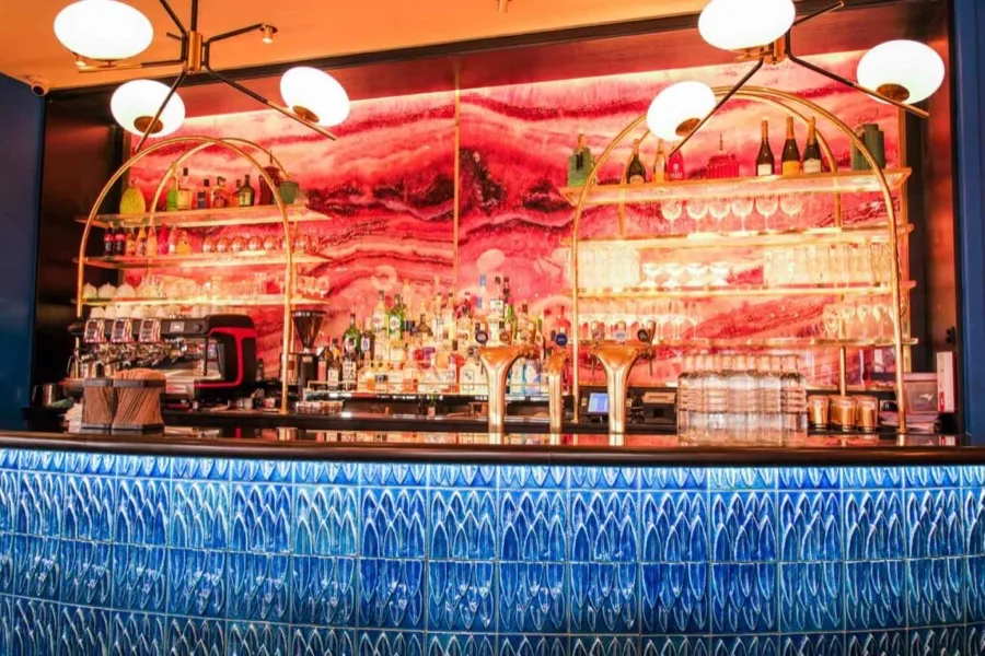 Le bar des Pipelettes du Boulevard, fresque rose et comptoir carrelé de bleu