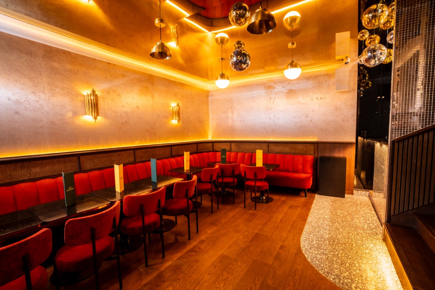 The Velvet Club at Les Causeurs, red velvet banquettes and round tables